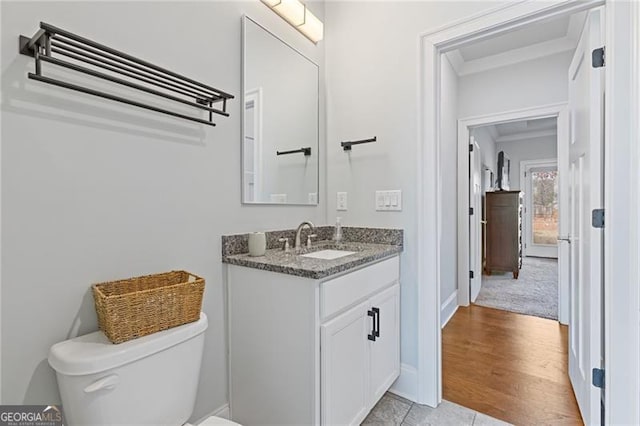 bathroom with hardwood / wood-style floors, vanity, and toilet