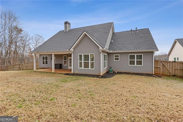 rear view of house with a lawn and a patio area