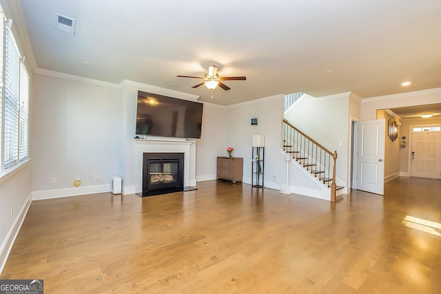 unfurnished living room with ceiling fan, wood-type flooring, and crown molding