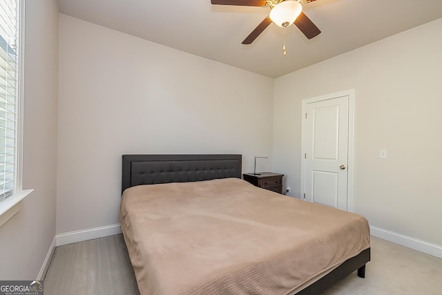 bedroom with light carpet, multiple windows, and ceiling fan