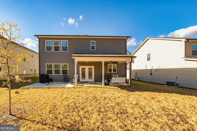 back of house featuring central AC unit, a patio area, a lawn, and french doors