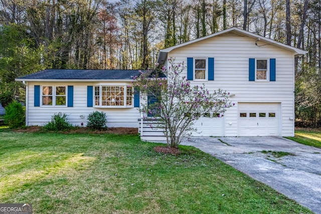 tri-level home featuring a front yard, a garage, and concrete driveway