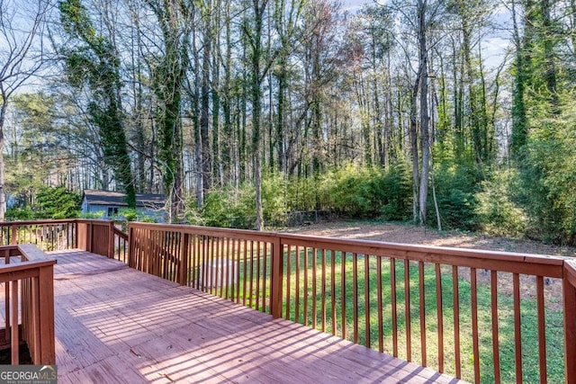wooden terrace featuring a lawn