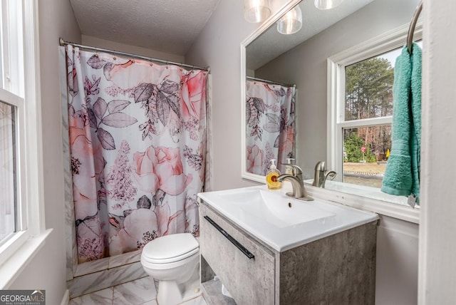 full bathroom featuring a shower with curtain, vanity, toilet, a textured ceiling, and marble finish floor