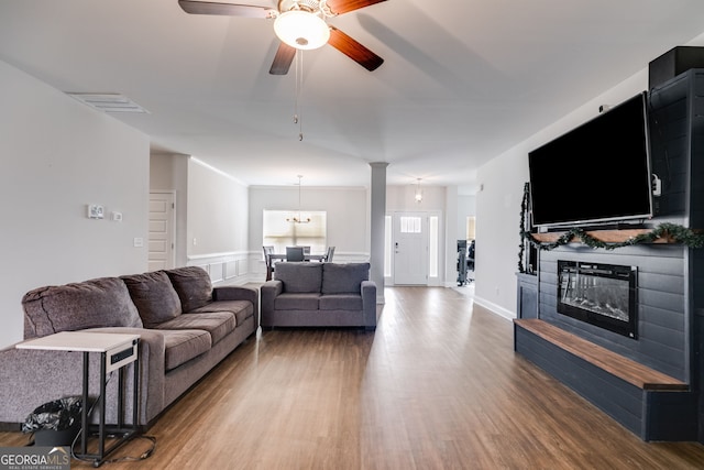 living room with hardwood / wood-style floors and ceiling fan with notable chandelier