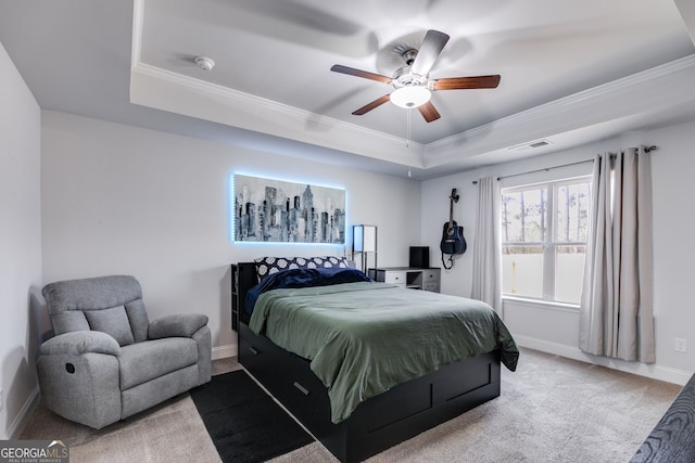 carpeted bedroom featuring crown molding, ceiling fan, and a tray ceiling