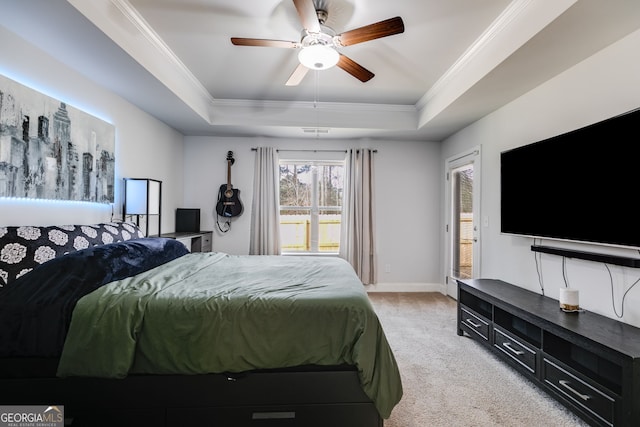 bedroom with ceiling fan, light colored carpet, ornamental molding, and a tray ceiling