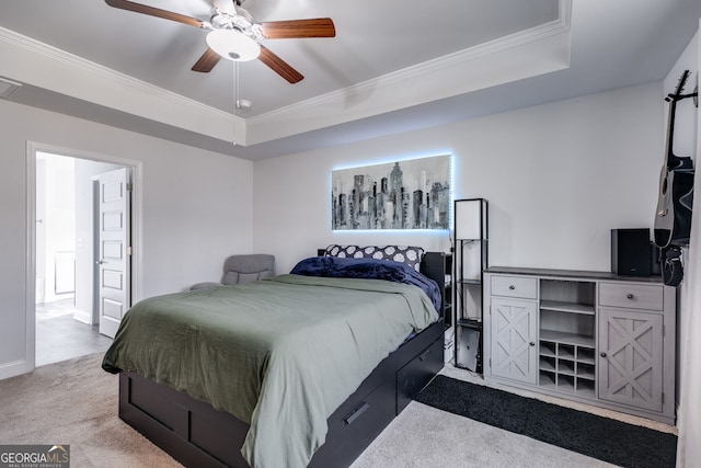 carpeted bedroom featuring ceiling fan, ornamental molding, and a raised ceiling