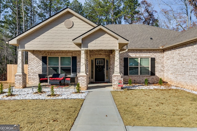 view of front facade with covered porch and a front yard