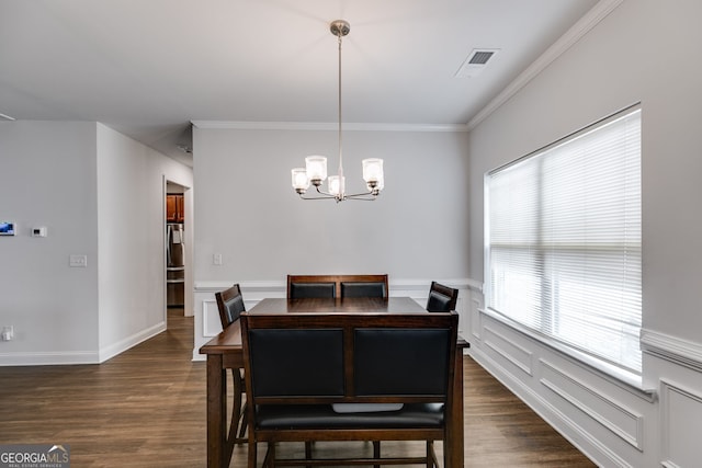 dining area with a notable chandelier, crown molding, and dark hardwood / wood-style floors