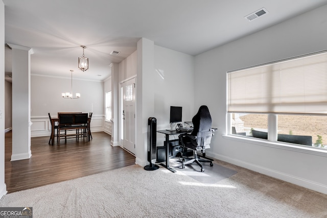 carpeted home office with a healthy amount of sunlight, crown molding, a chandelier, and ornate columns