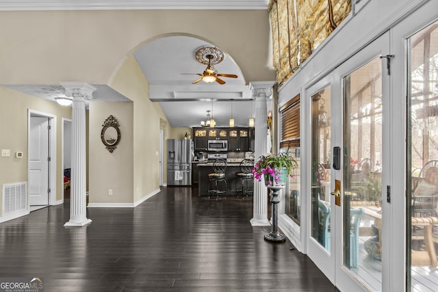 interior space featuring lofted ceiling, ornate columns, dark wood-type flooring, and french doors