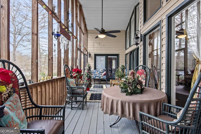 sunroom / solarium with a wealth of natural light, lofted ceiling, and ceiling fan