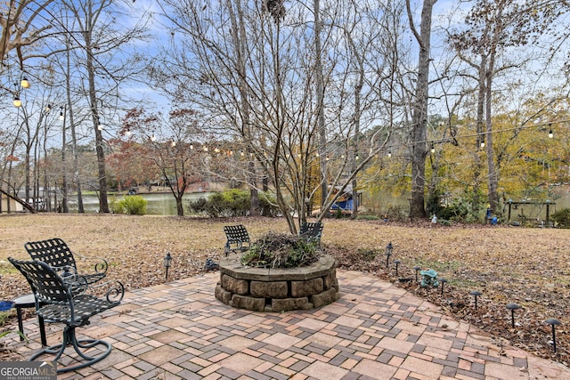 view of patio featuring a water view and an outdoor fire pit