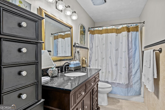 bathroom with tile patterned flooring, a textured ceiling, vanity, and toilet