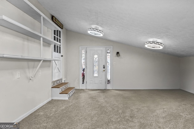 entrance foyer with a textured ceiling, carpet floors, and vaulted ceiling