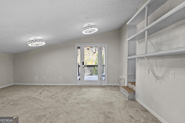 interior space with a textured ceiling and lofted ceiling