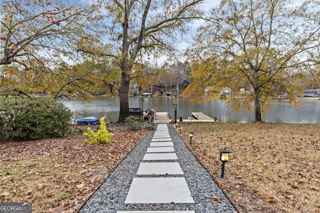 view of yard with a water view and a dock