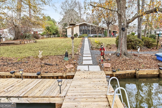 dock area with a water view and a lawn