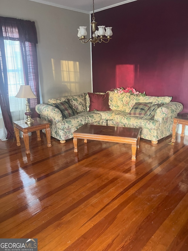 living room featuring hardwood / wood-style floors, an inviting chandelier, and crown molding