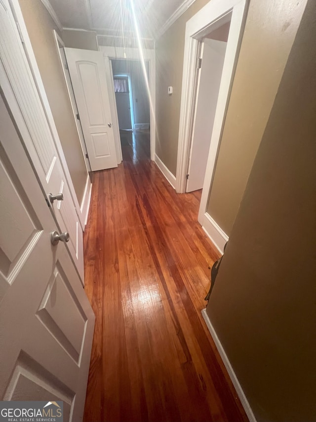 hallway with crown molding and hardwood / wood-style floors