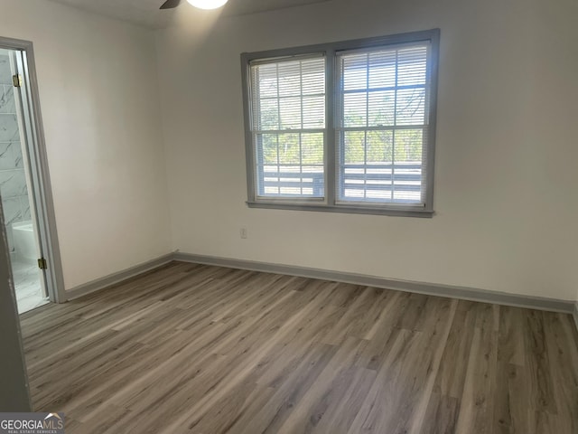 empty room with ceiling fan and dark hardwood / wood-style flooring