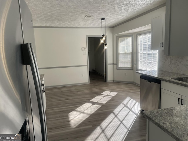 kitchen with decorative backsplash, hanging light fixtures, appliances with stainless steel finishes, white cabinets, and dark hardwood / wood-style flooring