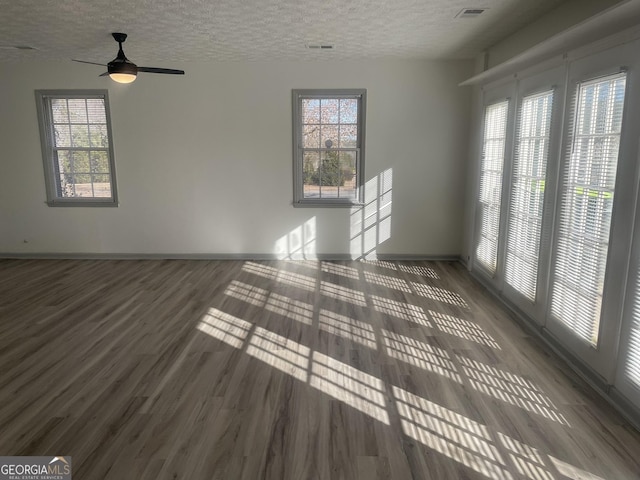 spare room with ceiling fan, dark wood-type flooring, and a textured ceiling