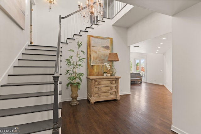 staircase with a towering ceiling and hardwood / wood-style floors