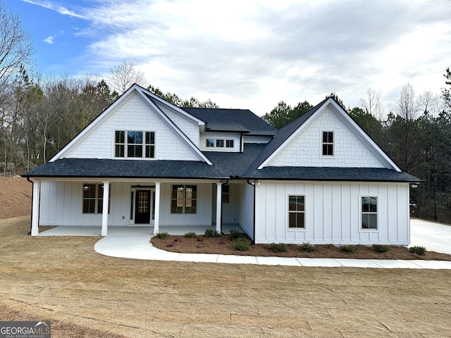 modern farmhouse style home with covered porch, a shingled roof, and board and batten siding