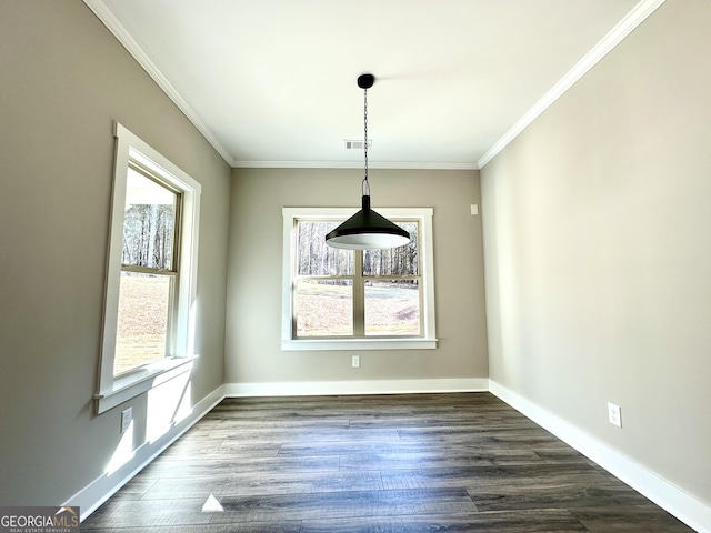 unfurnished dining area featuring ornamental molding, dark wood finished floors, and baseboards