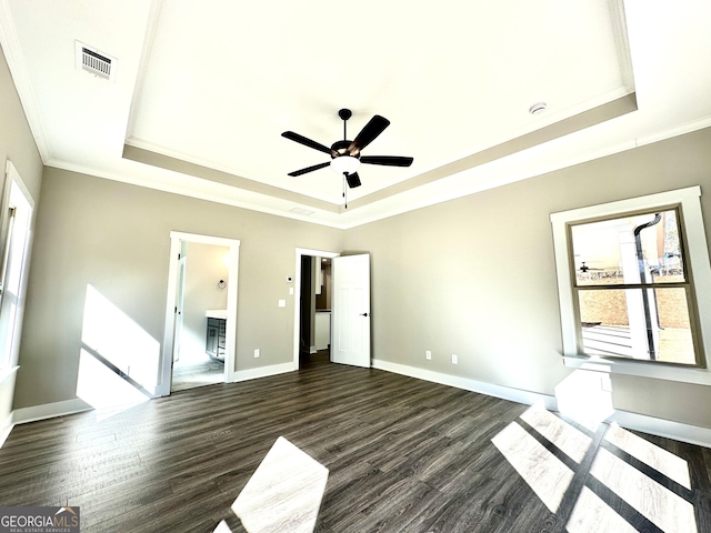 unfurnished bedroom featuring baseboards, visible vents, a raised ceiling, and dark wood-type flooring