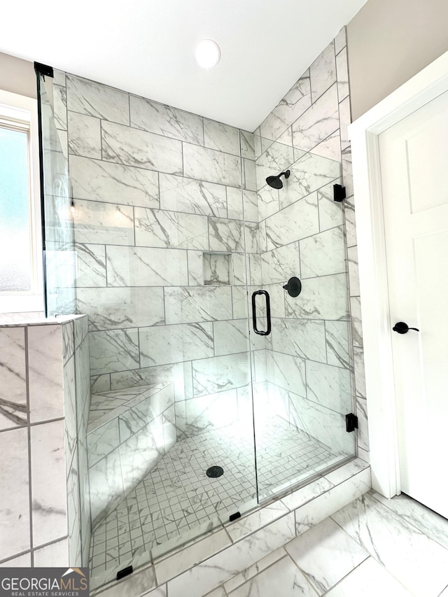 full bathroom with a stall shower and marble finish floor