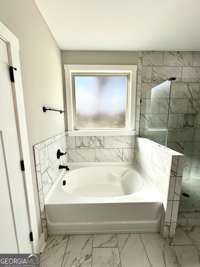 bathroom featuring marble finish floor, walk in shower, and a bath