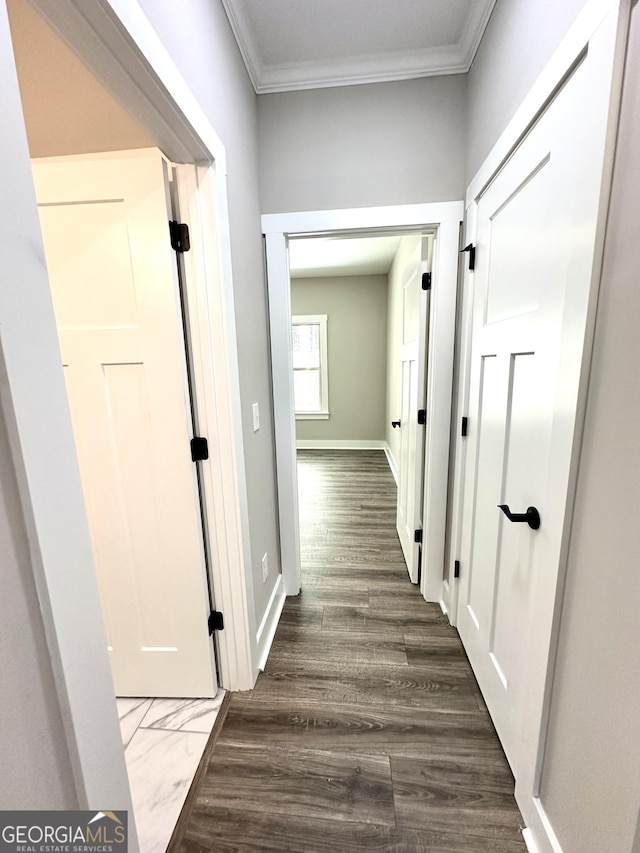 hall with dark wood-style floors, baseboards, and ornamental molding