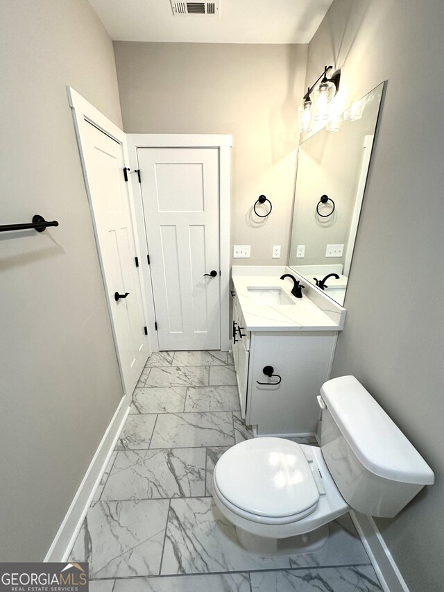 half bath with marble finish floor, visible vents, and baseboards