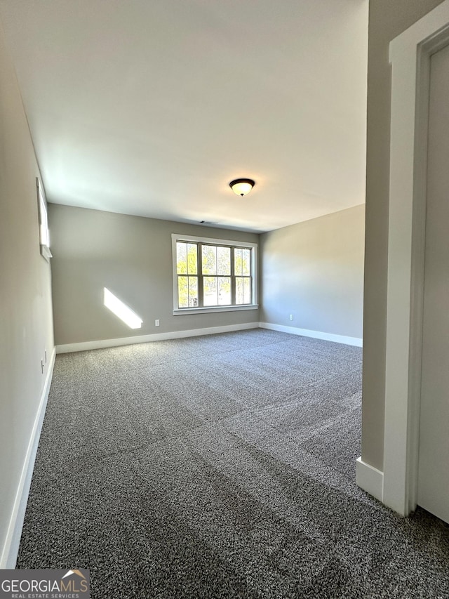 carpeted spare room featuring baseboards