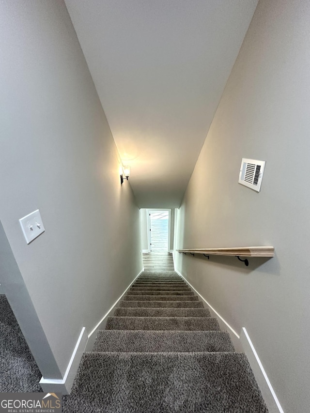 stairway with carpet floors, visible vents, and baseboards