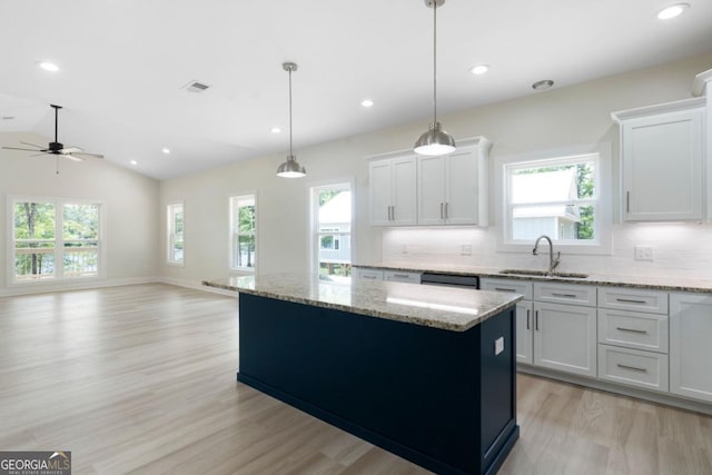 kitchen with white cabinetry, sink, a wealth of natural light, and vaulted ceiling