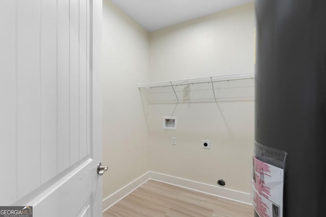 clothes washing area with electric dryer hookup, light hardwood / wood-style floors, electric water heater, and hookup for a washing machine