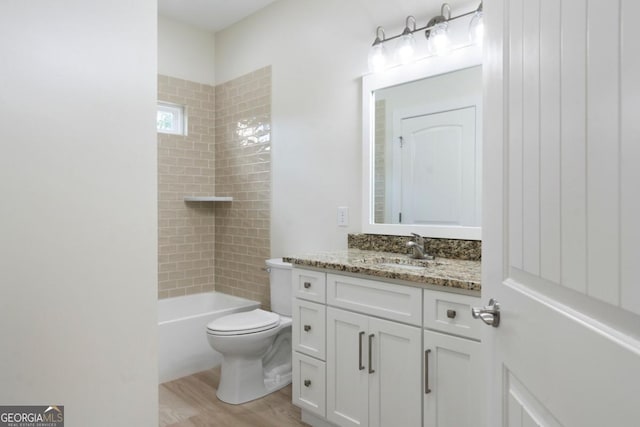 full bathroom featuring hardwood / wood-style flooring, vanity, toilet, and tiled shower / bath combo