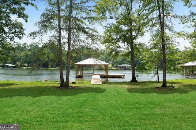 view of community featuring a lawn, a water view, and a gazebo