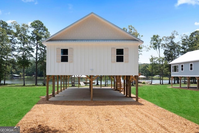 exterior space with a carport, a water view, and a yard