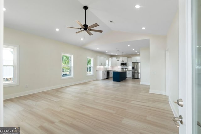 unfurnished living room with ceiling fan, lofted ceiling, and light hardwood / wood-style flooring