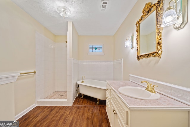 bathroom with vanity, wood-type flooring, a textured ceiling, and independent shower and bath