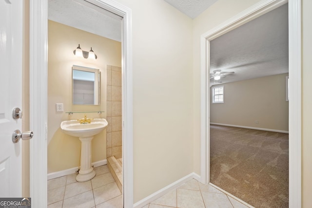 bathroom featuring tile patterned floors, sink, ceiling fan, a textured ceiling, and walk in shower