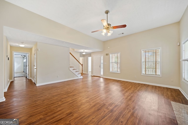 unfurnished living room with ceiling fan and dark wood-type flooring