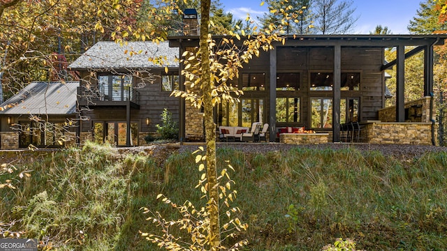 rear view of property featuring outdoor lounge area and a balcony