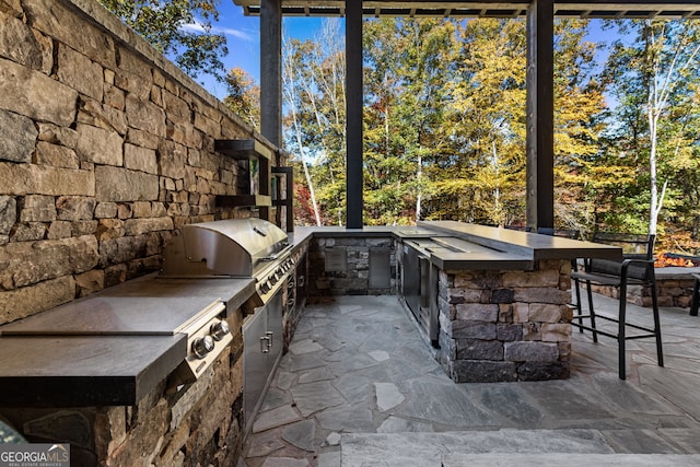 view of patio featuring a grill, exterior kitchen, and an outdoor bar