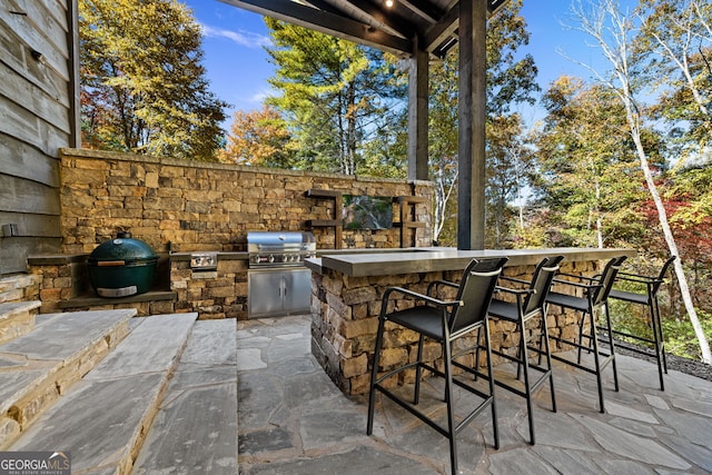 view of patio featuring exterior bar, area for grilling, and a grill